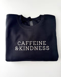 Caffeine & Kindness embroidered in cream thread on a Black crewneck