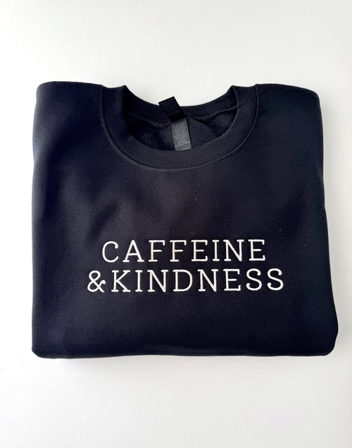 Caffeine & Kindness embroidered in cream thread on a Black crewneck