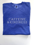 Caffeine and Kindness embroidered in white thread on a Flo Blue tee