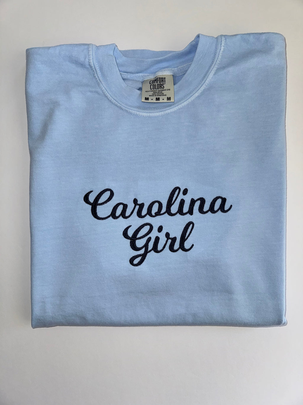 Carolina Girl embroidered in navy script on a Chambray tee