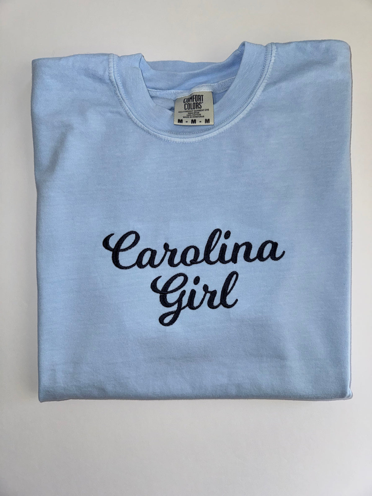Carolina Girl embroidered in navy script on a Chambray tee