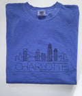 Charlotte skyline and CHARLOTTE embroidered in black thread on a Flo Blue tee