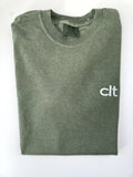 Small white clt embroidery on the chest of a folded Moss tee