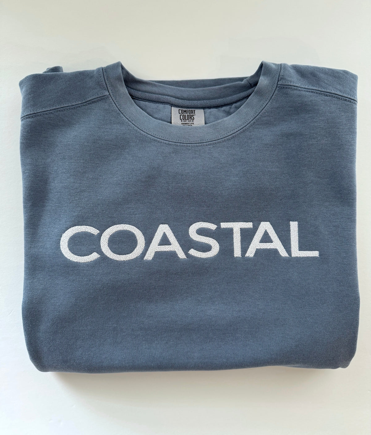 Coastal embroidery on a folded Blue Jean crewneck
