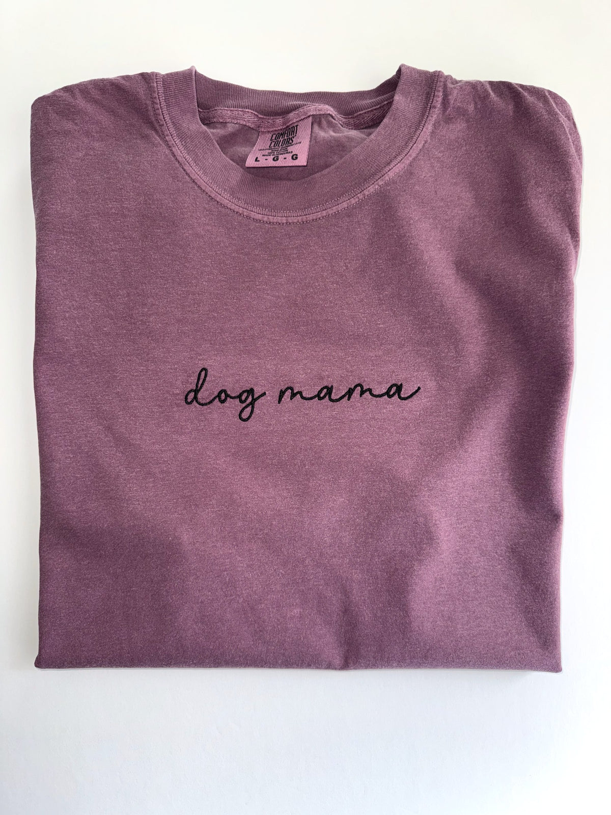 Dog mama embroidered in black script on a Berry tee