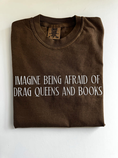 "Imagine being afraid of drag queens and books" embroidered tee in Espresso, folded flat with the collar showing