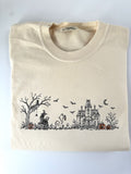 Haunted Manor Halloween scene embroidered in black thread with orange pumpkins on Ivory