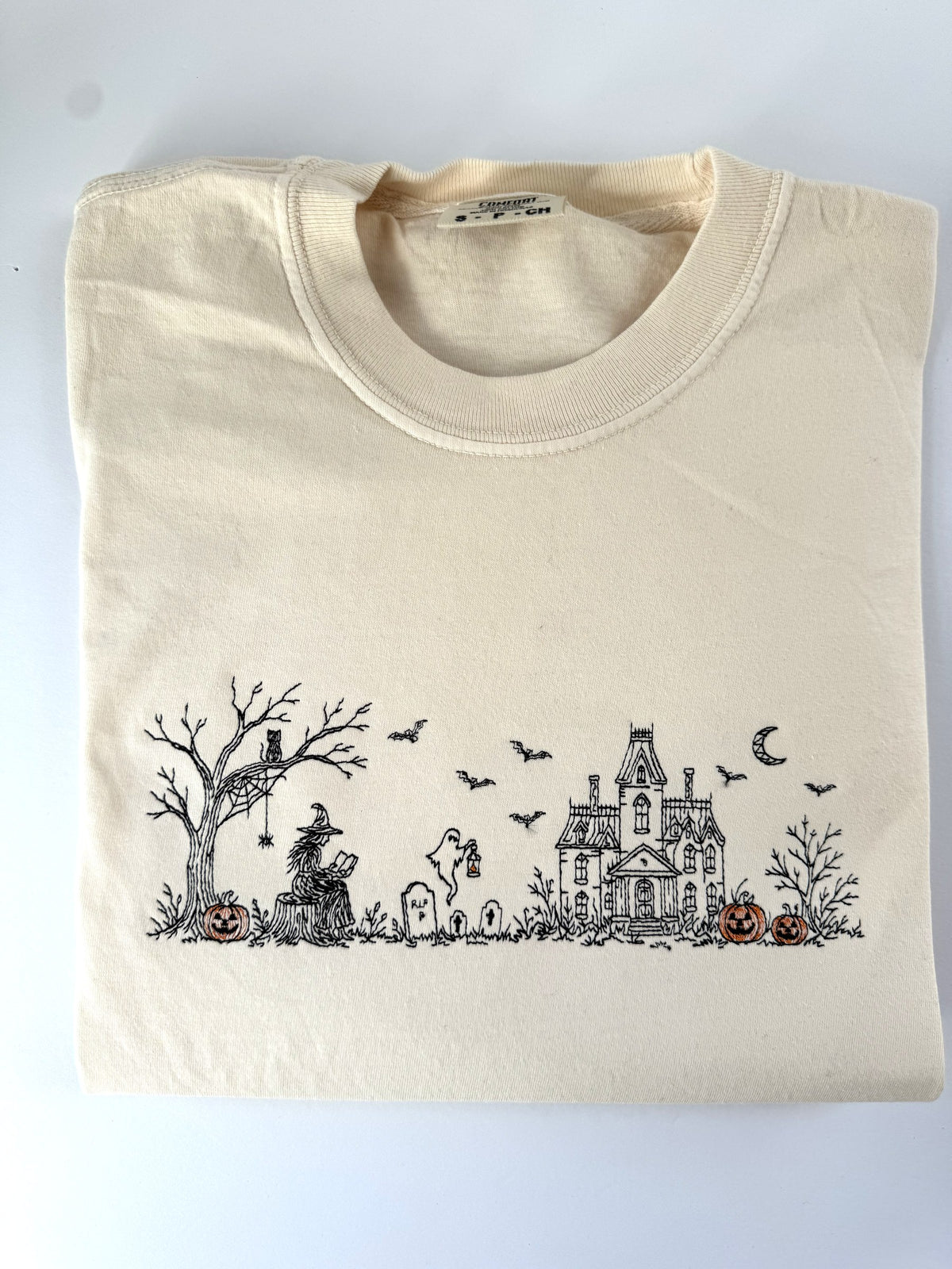 Haunted Manor Halloween scene embroidered in black thread with orange pumpkins on Ivory