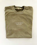 human kind be both embroidered in white thread on a Khaki tee