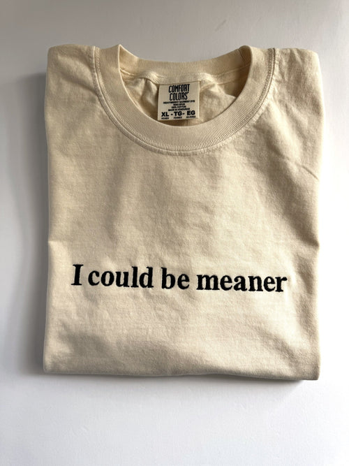 "I could be meaner" embroidered tee in Ivory, folded flat with the collar showing
