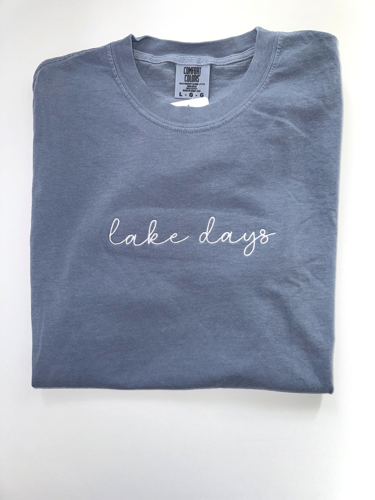 Lake Days embroidered tee in Blue Jean with white cursive script across the chest