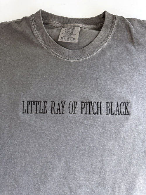 "Little ray of pitch black" embroidered tee in Pepper, laid flat, stitched tonal black on grey