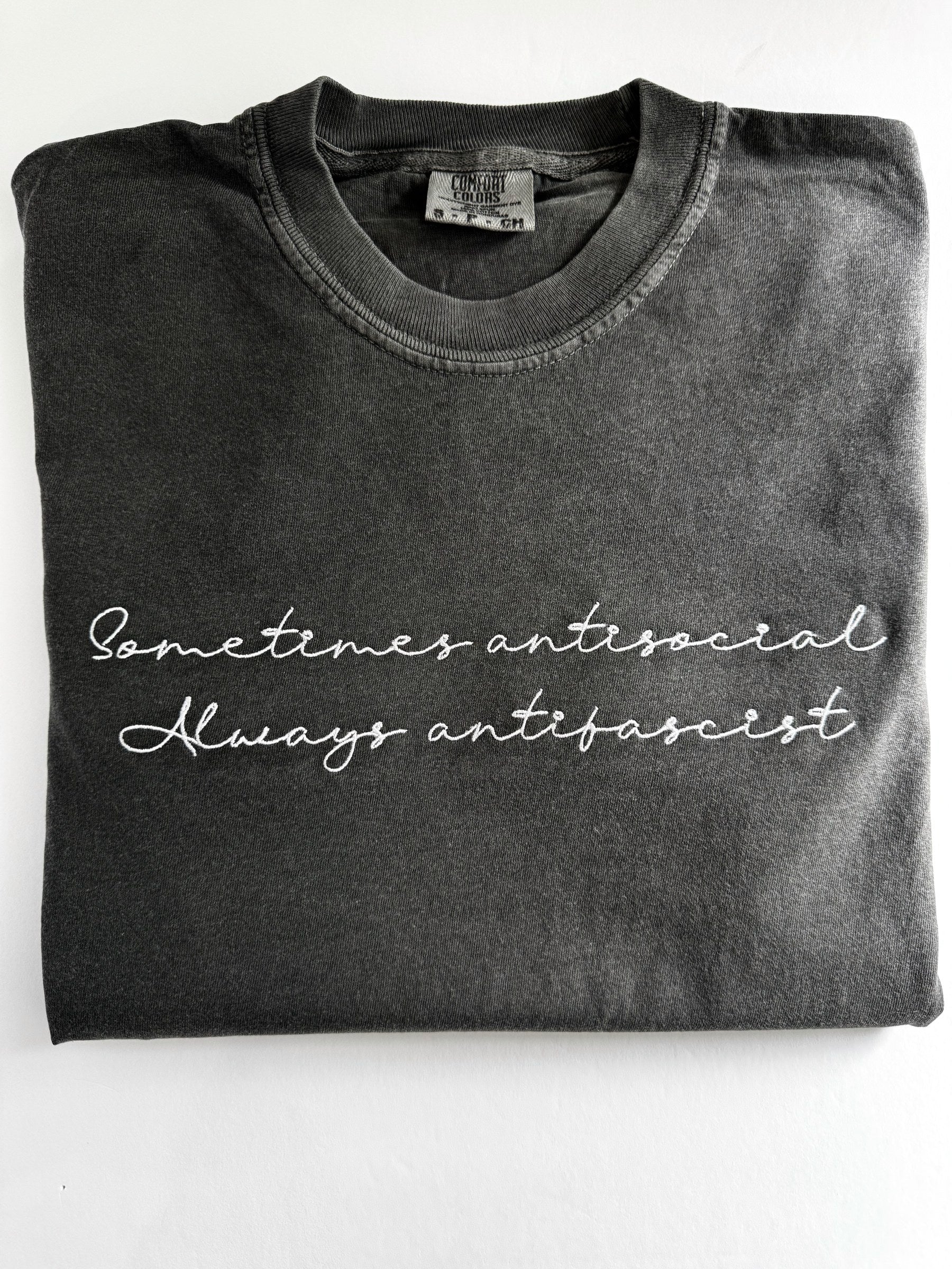"Sometimes antisocial, always antifascist" embroidered tee in Pepper, folded flat with the collar showing