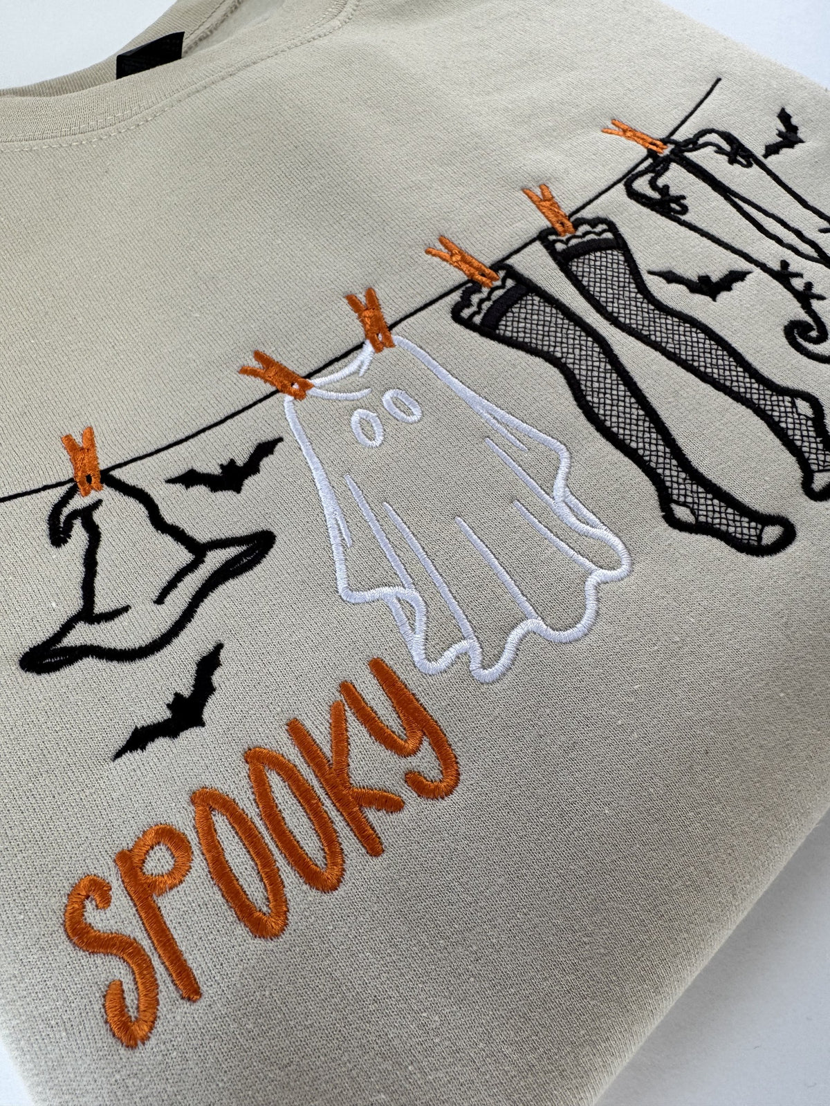 Close up of the fishnets, boots and SPOOKY lettering on the Sand clothesline crewneck