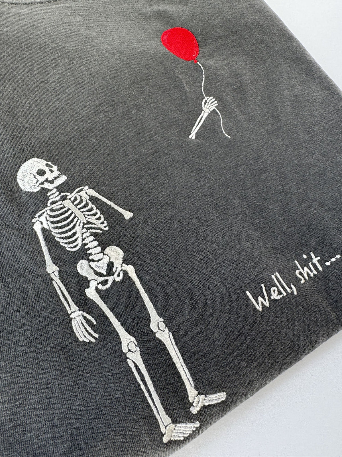 Close up of the embroidered skeleton and red balloon on Pepper