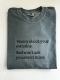 "Worry about your own sins. God won't ask you about mine." embroidered tee, folded flat with the collar showing